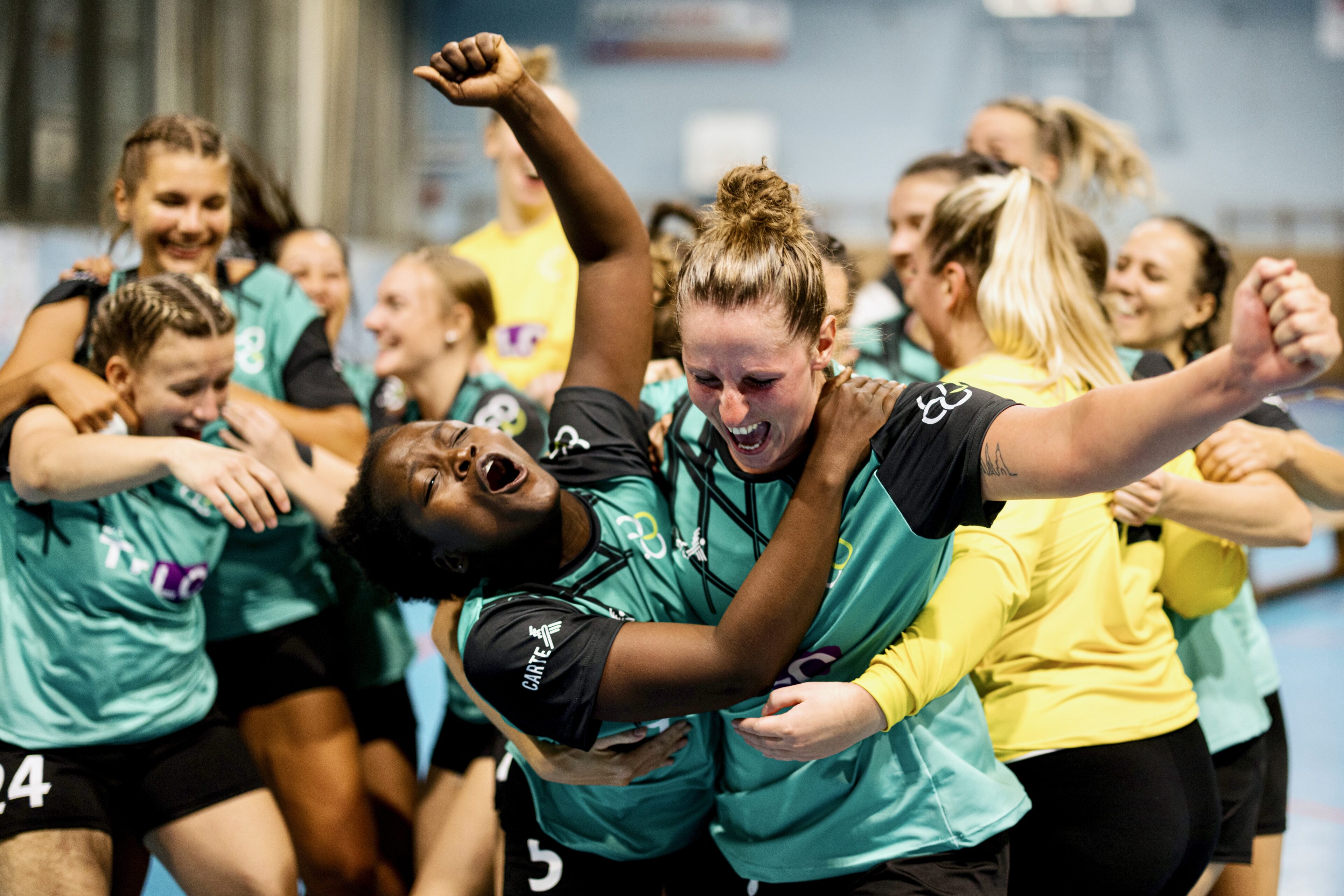 Female handball players celebrating victory after match